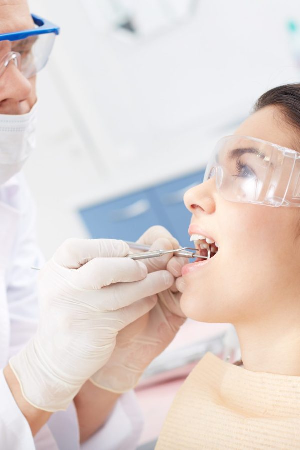 Young girl with open mouth during oral checkup at the dentists